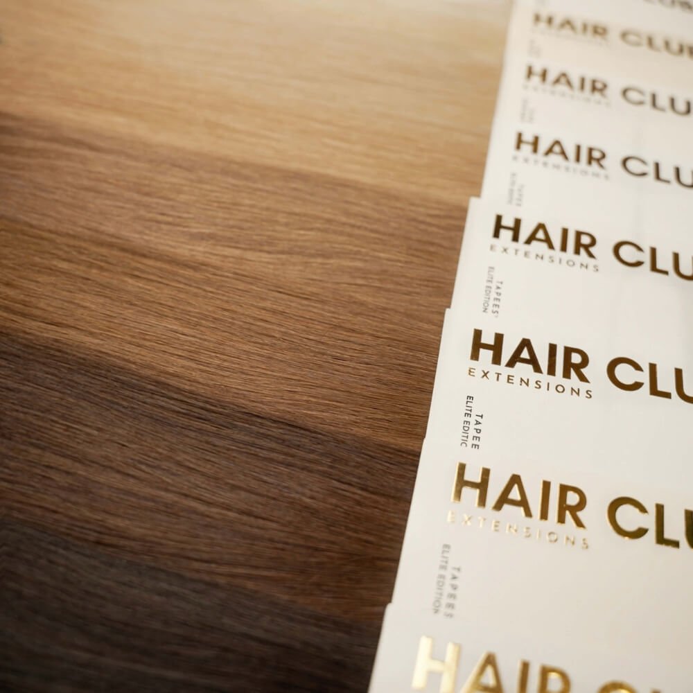 Human hair extensions laid out from blonde to brunette