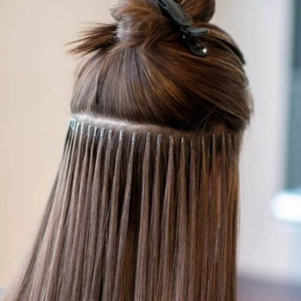 Micro ring hair extension attachment showing the small metal bead clamping extension hair to natural hair